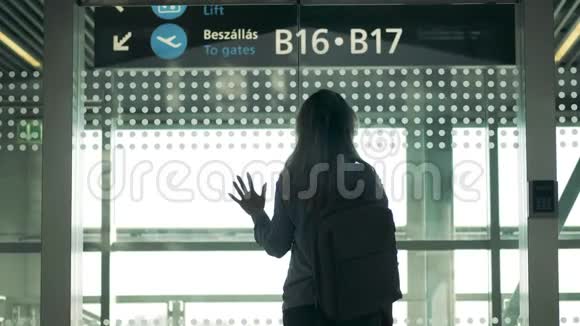 一位戴着医用口罩的女士站在候机室视频的预览图