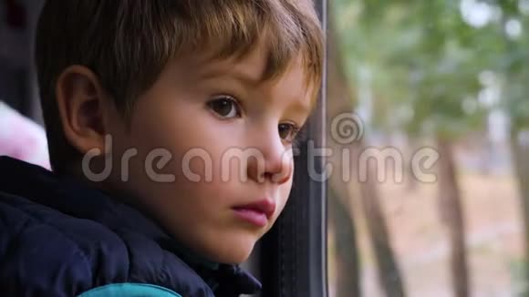 可怜的年轻乘客一个好奇的小男孩在火车上向窗外看的特写镜头面部表情坏坏坏坏视频的预览图