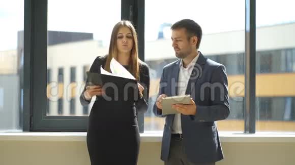 女商人和商人站在办公室讨论商业想法视频的预览图