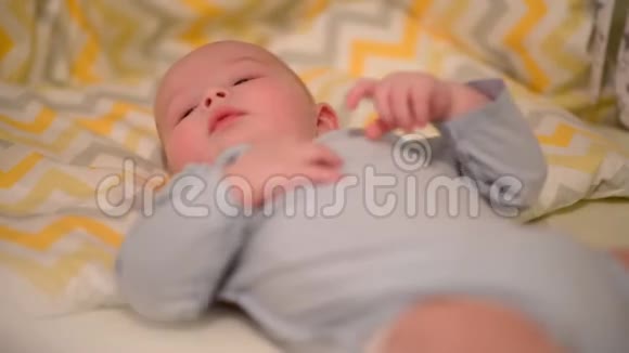 小婴儿仰卧在婴儿床上视频的预览图