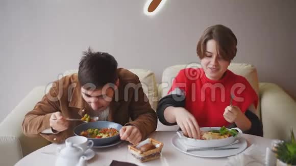 一男一女在餐厅吃午饭一对年轻夫妇正在咖啡馆里吃饭视频的预览图