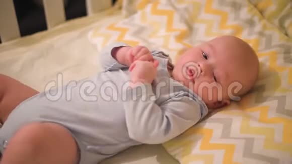 新生儿躺在婴儿床上微笑视频的预览图