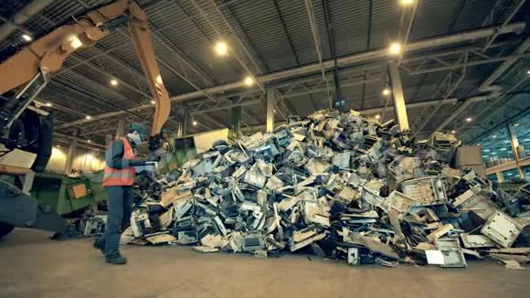 有一堆废物和一名工人观察的印度垃圾场视频的预览图