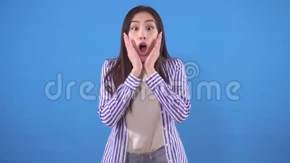 蓝色背景下一位快乐的年轻亚洲女人视频的预览图