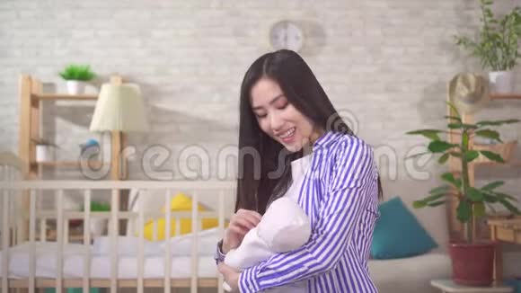 一位抱着婴儿面带微笑的年轻亚洲母亲的画像视频的预览图
