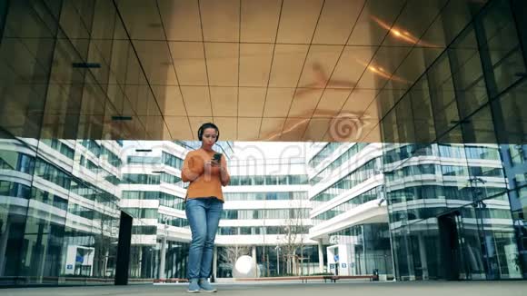 一个女人在一个现代化的城市里浏览她的手机视频的预览图