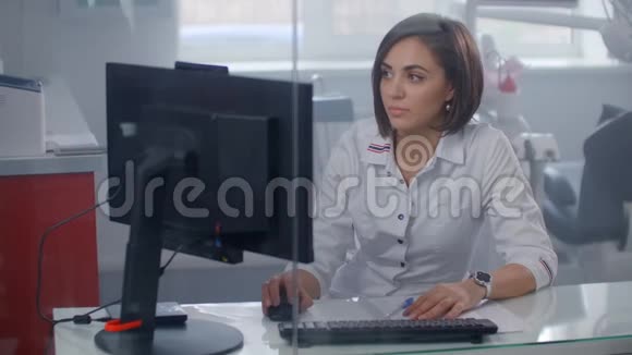 女医生坐在办公桌前用笔记本电脑工作视频的预览图