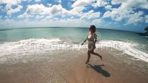一位美丽的女士在海滩上缓慢地奔跑视频的预览图