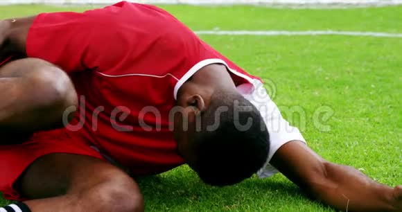 受伤的足球运动员躺在草地上视频的预览图