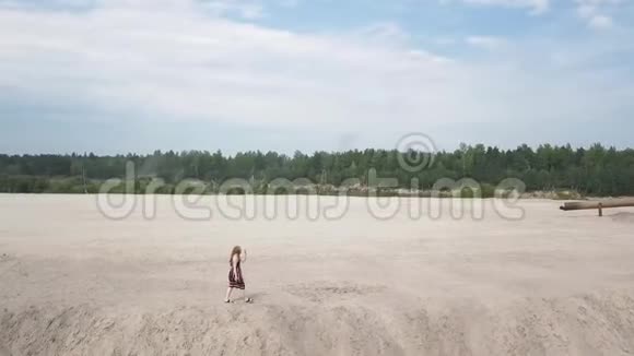 穿着日光浴的女孩走在沙坑的边缘视频的预览图