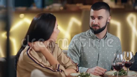 男人和女人坐在餐桌上在餐馆里吃和喝4k龙红相机视频的预览图