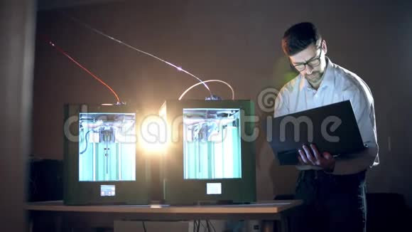 两名3D打印机在一名男性专家的监督下工作视频的预览图