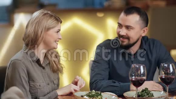 快乐的一对夫妇在餐厅享受约会时微笑着交谈4k龙红相机视频的预览图