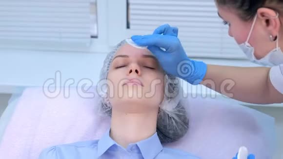 美容师用麻醉剂从面部擦拭霜然后再进行生物消毒视频的预览图