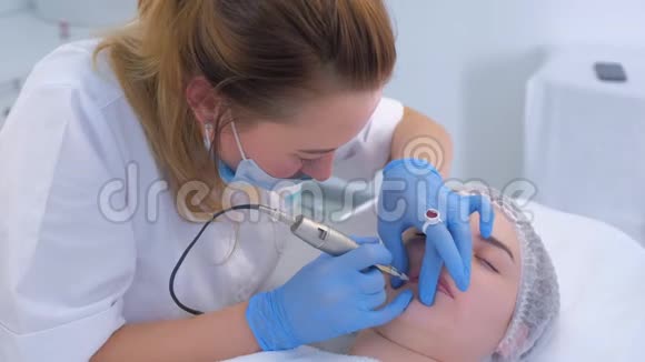 美容师使用纹身机在女性嘴唇上涂永久性化妆品视频的预览图