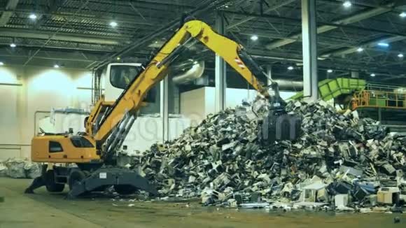 机械装载机正在室内运输垃圾垃圾垃圾废品回收厂视频的预览图
