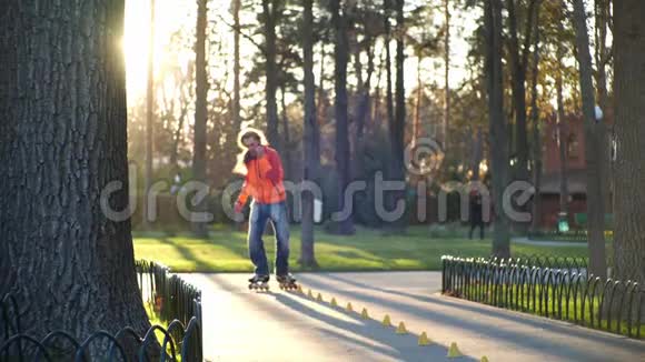 滚轴运动生活活跃和运动的男子表演专业轮滑技术在一个凉爽的城市公园一个视频的预览图