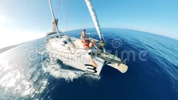 漂流船一位女士坐在船头拍摄自己暑假期间乘坐帆船的朋友视频的预览图