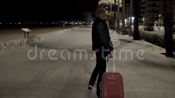 那个戴着帽子和手提箱的游客深夜在街上走视频的预览图