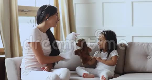 可爱的亚洲女孩戴着皇冠和妈妈玩木偶视频的预览图