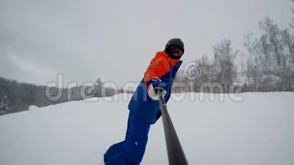 一个滑雪者从山上沿着森林滑雪道下来视频的预览图