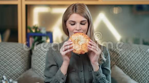 微笑的年轻女孩咬着开胃的烤面包的肖像中型近距离拍摄4k红色相机视频的预览图