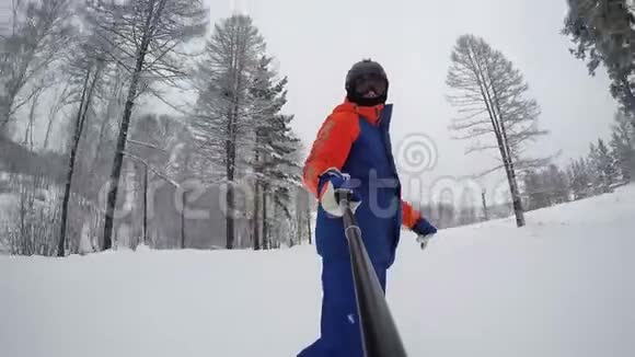 一个滑雪者从一座山上下来沿着冬天的森林背景是一个滑雪者视频的预览图