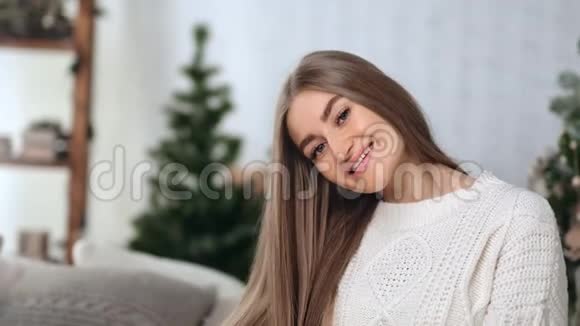 美丽的年轻女性在圣诞树上微笑的肖像中型近距离拍摄4k红色相机视频的预览图