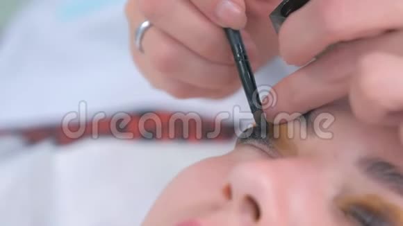 美容师正在给客户画黑色眼睛特写的女人睫毛视频的预览图