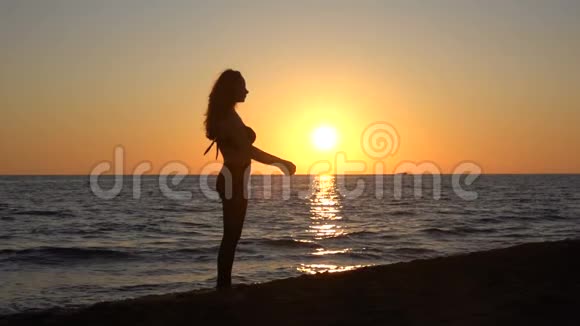 海上日落时跳跃的女孩剪影视频的预览图