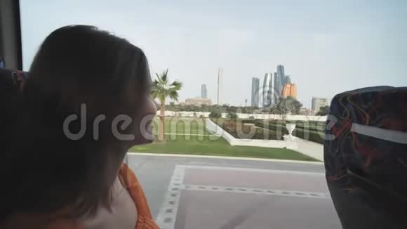一个女孩乘公共汽车穿过阿布扎比市阿联酋视频的预览图