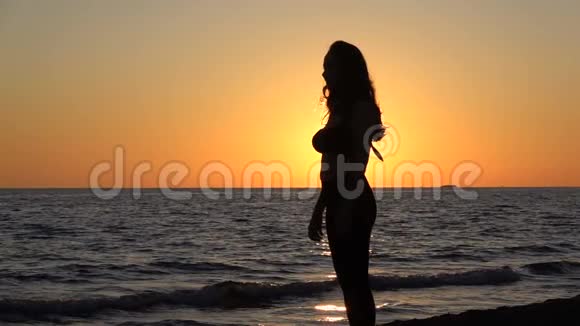 海上日落时跳跃的女孩剪影视频的预览图