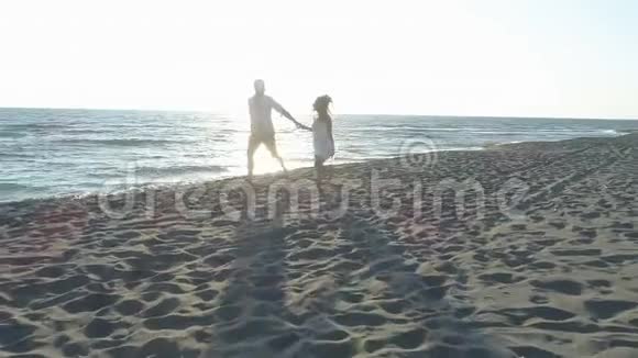 鸟瞰情侣在水边海滩上嬉戏视频的预览图