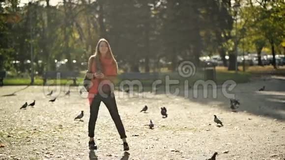 美丽的年轻女子学生背着背包在秋天的公园散步背景是飞鸟视频的预览图