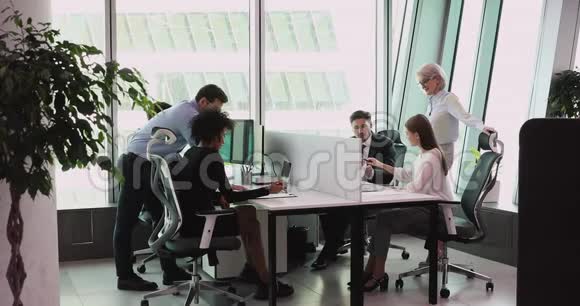 在大办公室里使用电脑说话的黑人员工视频的预览图