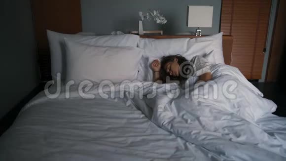 年轻的白种人女人睡在旅馆房间的床上视频的预览图
