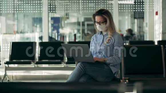 戴着安全面罩的漂亮女人正在用笔记本电脑工作视频的预览图