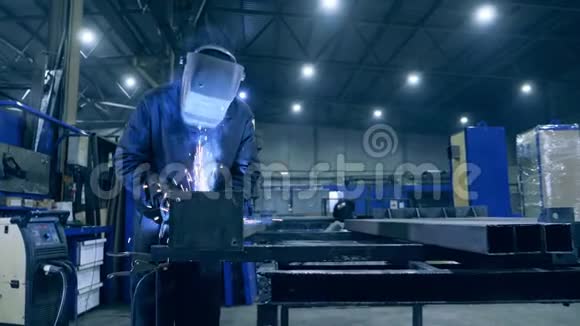 男性焊工在一个车间与金属一起工作在工厂设施工作的专业焊工视频的预览图