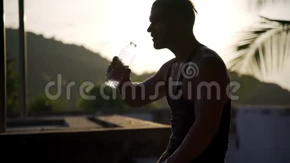 运动员在户外健身房用瓶子喝水视频的预览图