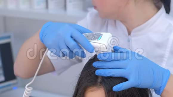 医生在临床上使用皮肤镜检查女性患者头发视频的预览图