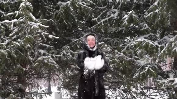 快乐的女人在冬天的公园里玩雪和扔雪视频的预览图