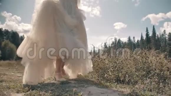 一个穿着白色连衣裙和鞋子在草地上奔跑的女孩的侧面景色视频的预览图
