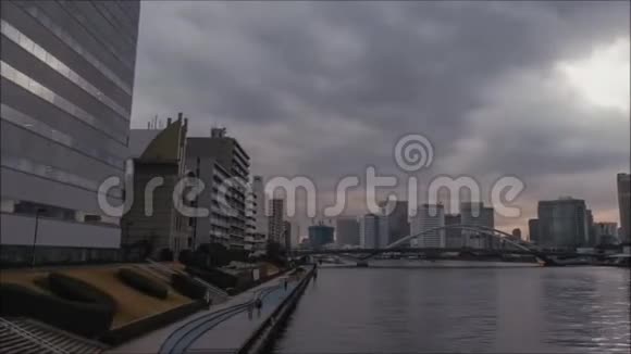 灰色的雨云在快速的时间流逝黑暗的天空笼罩着东京市中心的金融区由河流构成的建筑视频的预览图