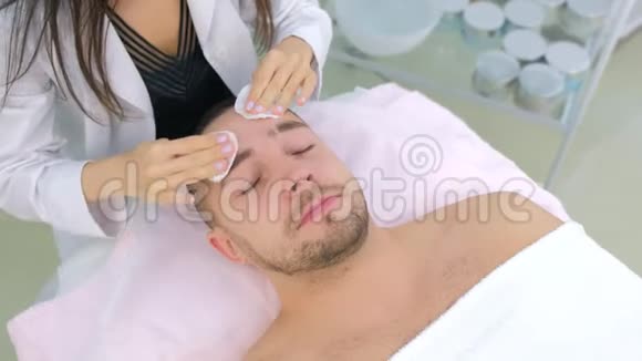 美容诊所女美容医生清洁面部手术的男人视频的预览图