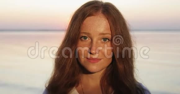 年轻快乐的女人的肖像红色卷发看着镜头微笑视频的预览图