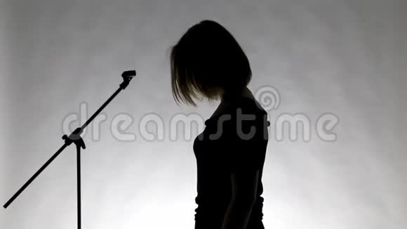 一个女孩的黑色剪影用微镜唱歌视频的预览图