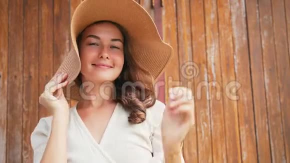 一位戴着一顶大草帽的年轻开朗的白种人女子的肖像视频的预览图