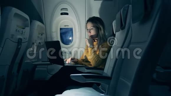 一位女士在飞行过程中在笔记本电脑上工作时考虑周到视频的预览图
