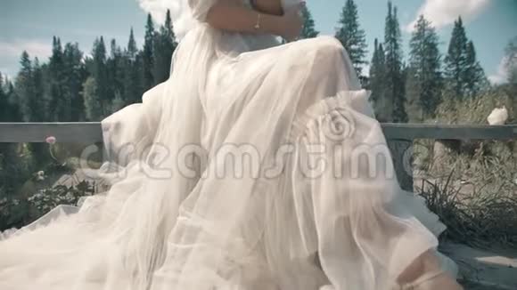 穿着白色裙子的金发女孩坐在湖边视频的预览图