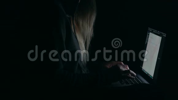 头罩里的黑客在暗室里用笔记本电脑打字视频的预览图